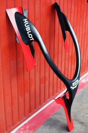 Black and red Halo device leaning up against a red garage wall